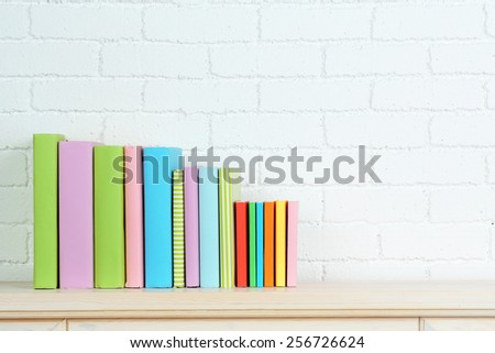 Books on shelf on wall background