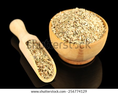 Dried parsley in wooden bowl, isolated on black