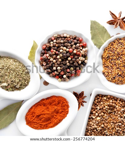 Different kinds of spices in ceramics bowls isolated on white