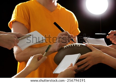 Autographs by American football star on black and lights background