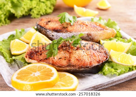Tasty baked fish on plate on table close-up