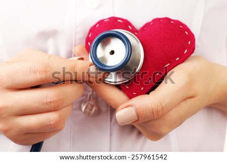 Doctor hands with heart and stethoscope, closeup