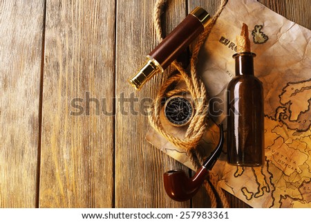 Marine still life spyglass, rope, pipe and world map on wooden background