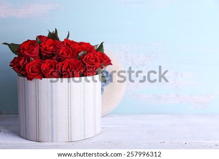 Bouquet of red roses in textile box on wooden background