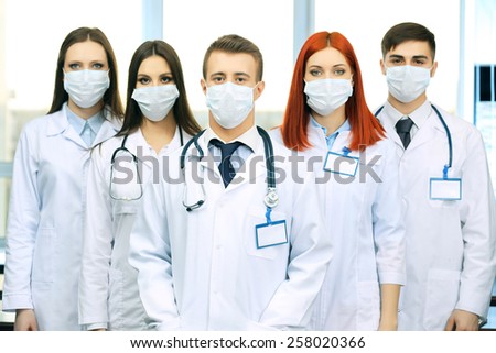 Medical workers in medical masks in conference room