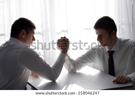 Arm wrestling of business people in office
