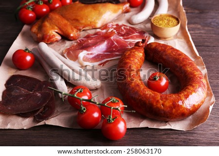 Assortment of deli meats on parchment on wooden table background