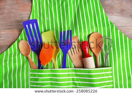 Set of kitchen utensils in pocket of apron, closeup