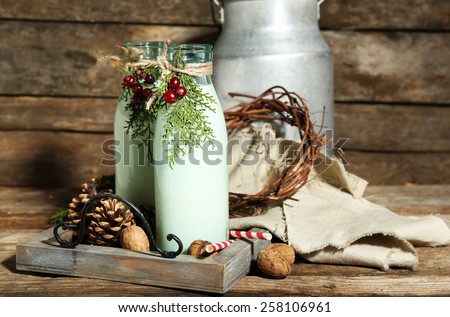 Bottles of fresh milk with natural decor, on wooden background