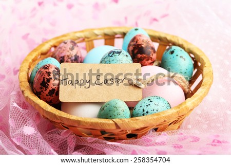 Bird colorful eggs in wicker basket on bright background