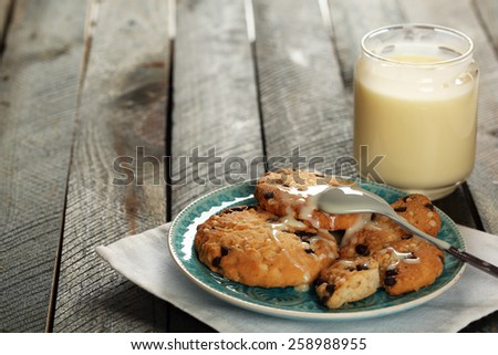 Cookies on plate with jar of condensed milk on wooden background