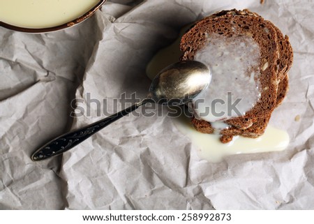Slices of bread with condensed milk on paper background