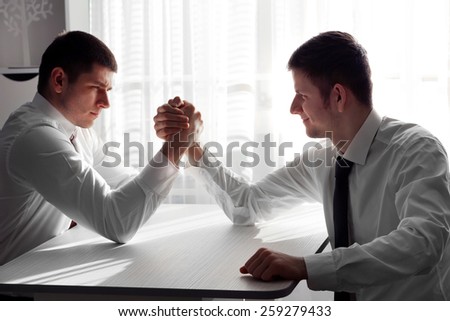 Arm wrestling of business people in office