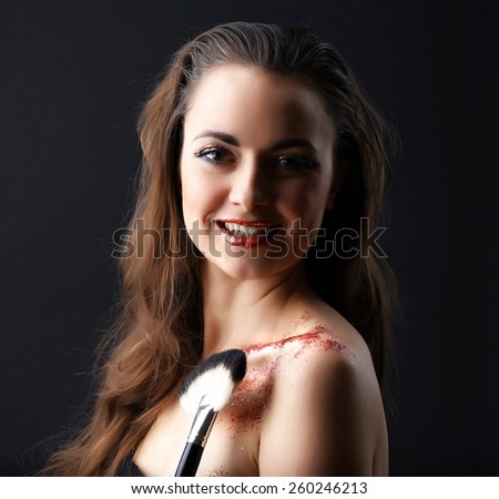 Portrait of beautiful woman with fancy glitter makeup on dark background