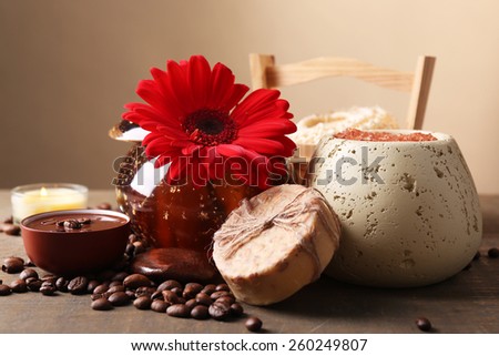 Composition of spa treatment, flowers and coffee beans on wooden table, on light color background