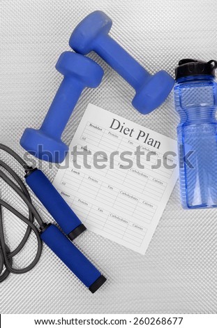 Diet plan and sports equipment top view close-up