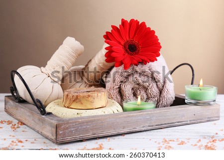 Composition of spa stones, sea salt and massage bags on wooden table, on light color background