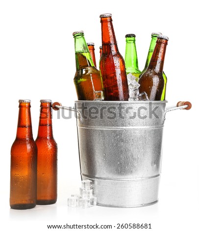 Glass bottles of beer in metal bucket isolated on white