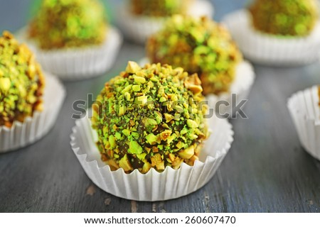 Tasty homemade pistachio candies on wooden table