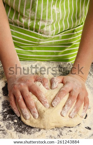 Making dough by female hands on wooden table background