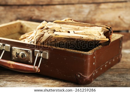 Old wooden suitcase with old books on wooden background