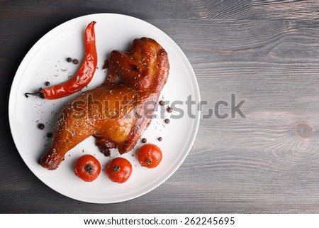 Smoked chicken leg  with vegetables on plate on wooden background