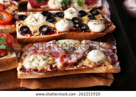 Different sandwiches with vegetables and cheese on pan close up