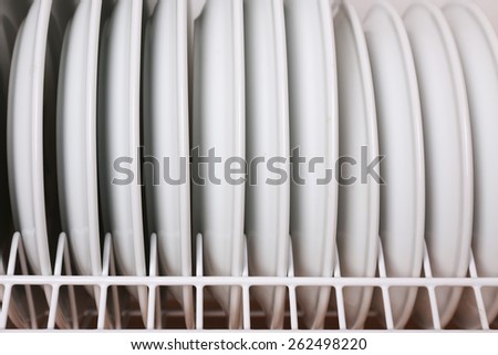 Clean plates drying on metal dish rack close up
