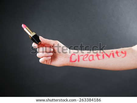 Word creativity written on female hand on black background