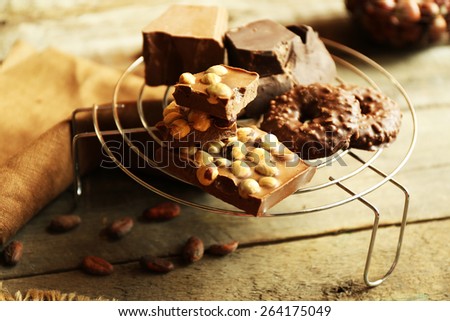 Still life with set of chocolate with nuts on metal stand, closeup