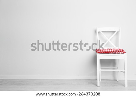Modern chair with pillow on white wall background