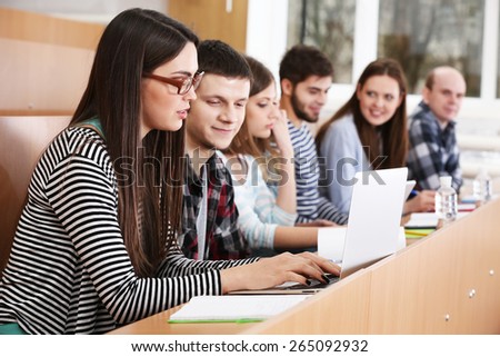 Group of students using gadgets in classroom