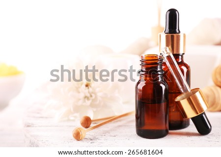 Spa dropper bottles with essence on wooden table, closeup