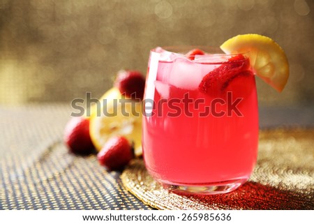Glass of freshness lemonade with strawberries, on bright background