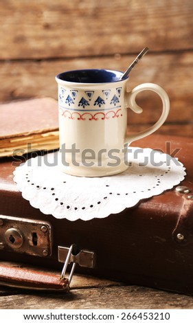 Old wooden suitcase with old books on wooden background
