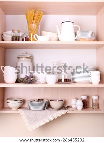 Kitchen utensils and tableware on wooden shelves