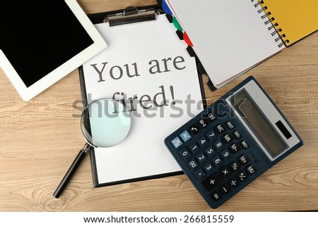 Message You\'re Fired on clapboard on wooden table, top view