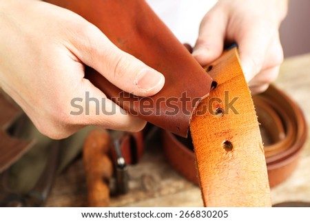 Repairing leather belt in workshop
