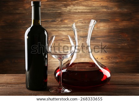Glass carafe of wine on wooden background