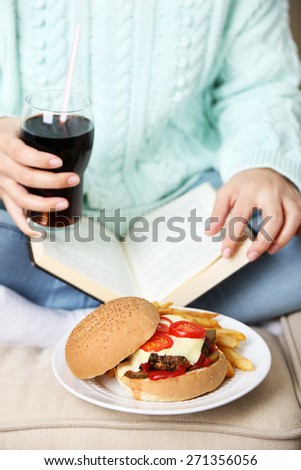 Woman with unhealthy fast food, close-up