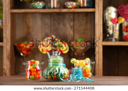 Colorful candies in jars on table in shop