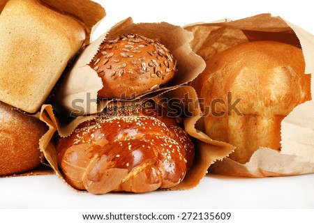 Fresh bread in paper bags on white background