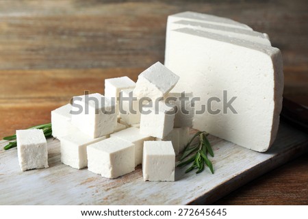 Sliced feta cheese with rosemary on table on wooden background