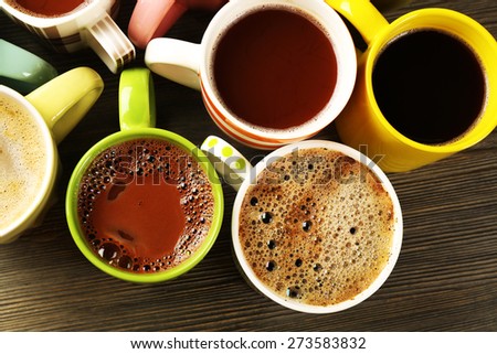 Many cups of coffee on wooden table, top view