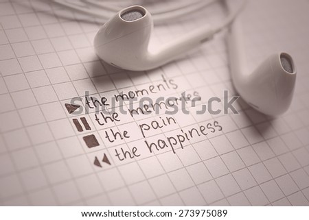 White earphones on notebook with text, closeup