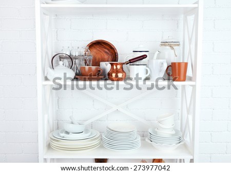 Kitchen shelving with dishes on white brick wall background
