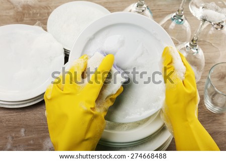 Female hand washing dish close up