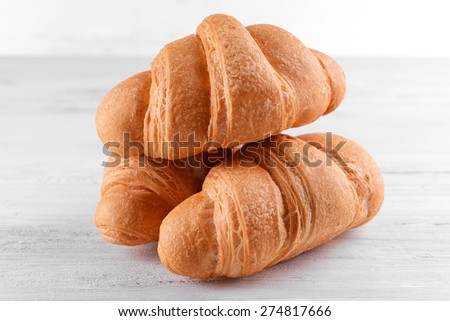 Delicious croissants on table on light background