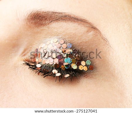 Female eye with fancy glitter makeup, macro view