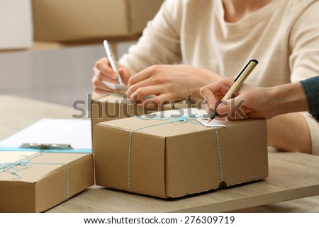 Women signs parcels in post office